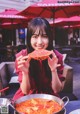 A woman sitting at a table with a plate of food.