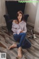 a woman sitting on the floor in front of a chair