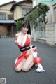 A woman in a red and white bikini sitting on the ground.